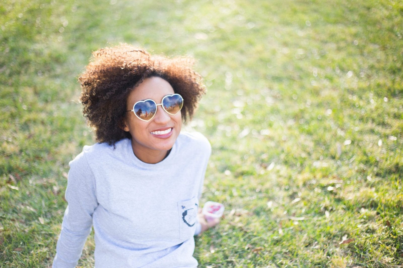15 not-so-little reminders why moms have earned rockstar status woman wearing heart sunglasses sitting on grass