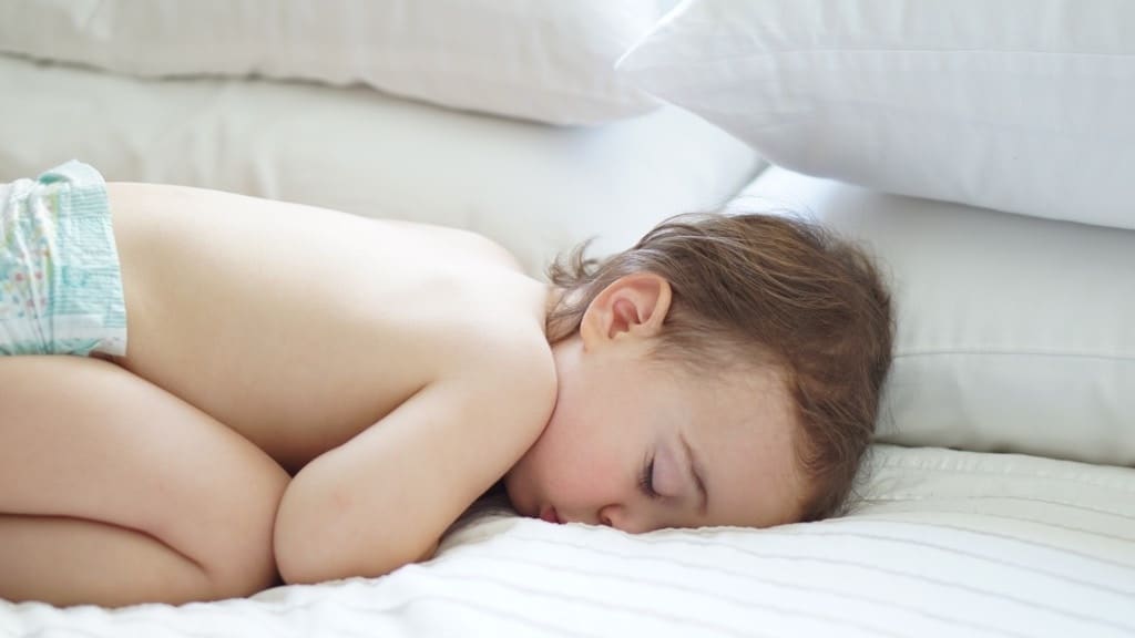 The secret to helping your children to sleep is actually all about your mood a baby sleeping on a bed