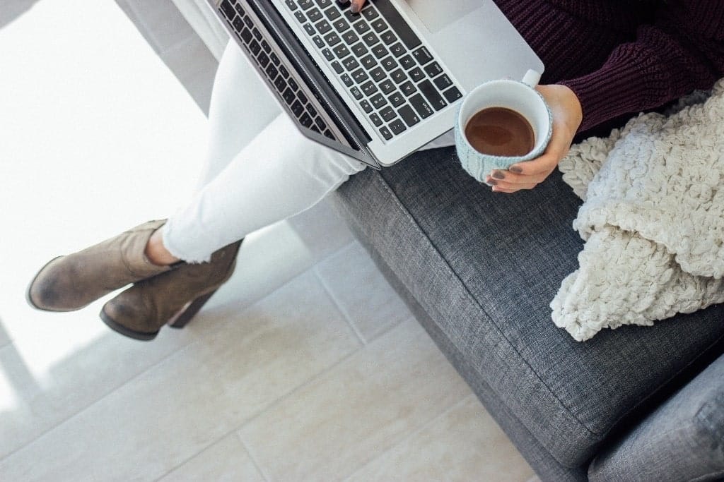 What we should learn from this employer’s response to a worker’s mental health day Woman sitting down with laptop and coffee cup