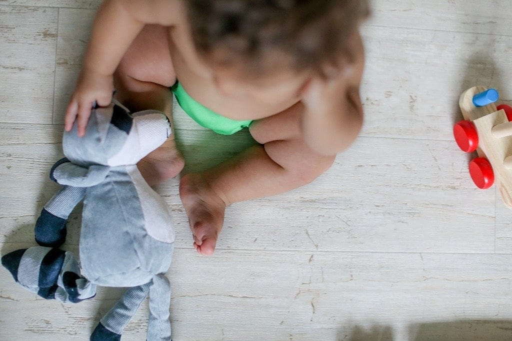 Report: Average U.S. family pays more than 30% of income on child care—and that hurts us all baby sitting on the ground