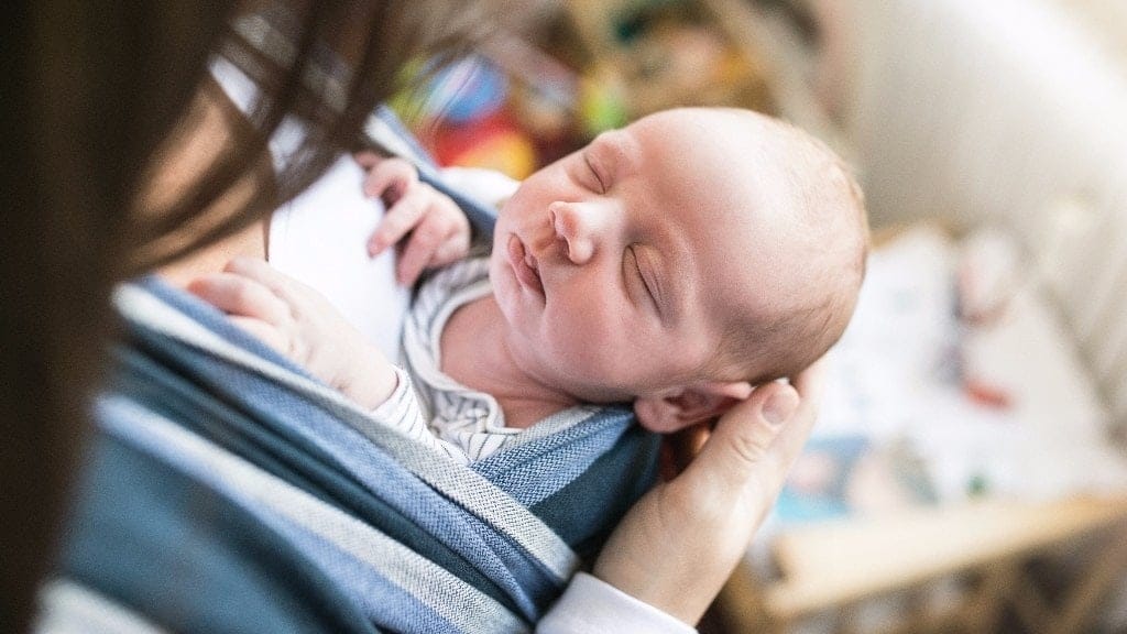 The rawness of motherhood cracks your heart wide open mom looking down at newborn baby-the rawness of motherhood