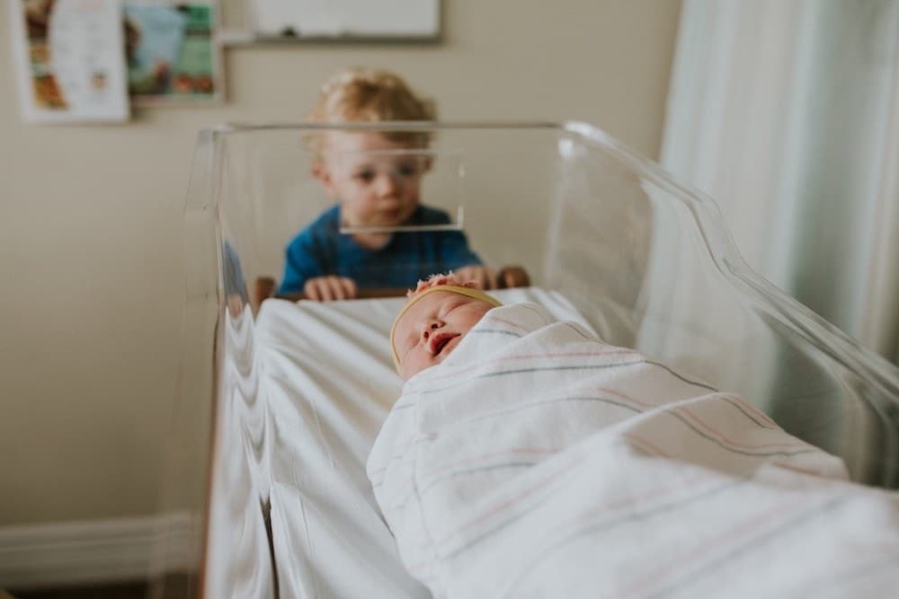 The United States is the most expensive country to give birth in boy looking at newborn baby after an expensive birth