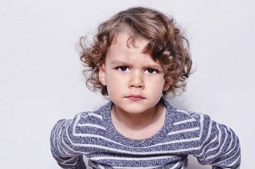 The real reason your kids act worse for you than anyone else—and how to help angry toddler looking at the camera