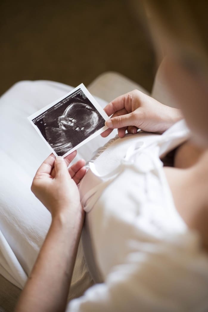 I can’t wait to meet you, baby, but I also want to keep you safe inside woman looking at an ultrasound picture