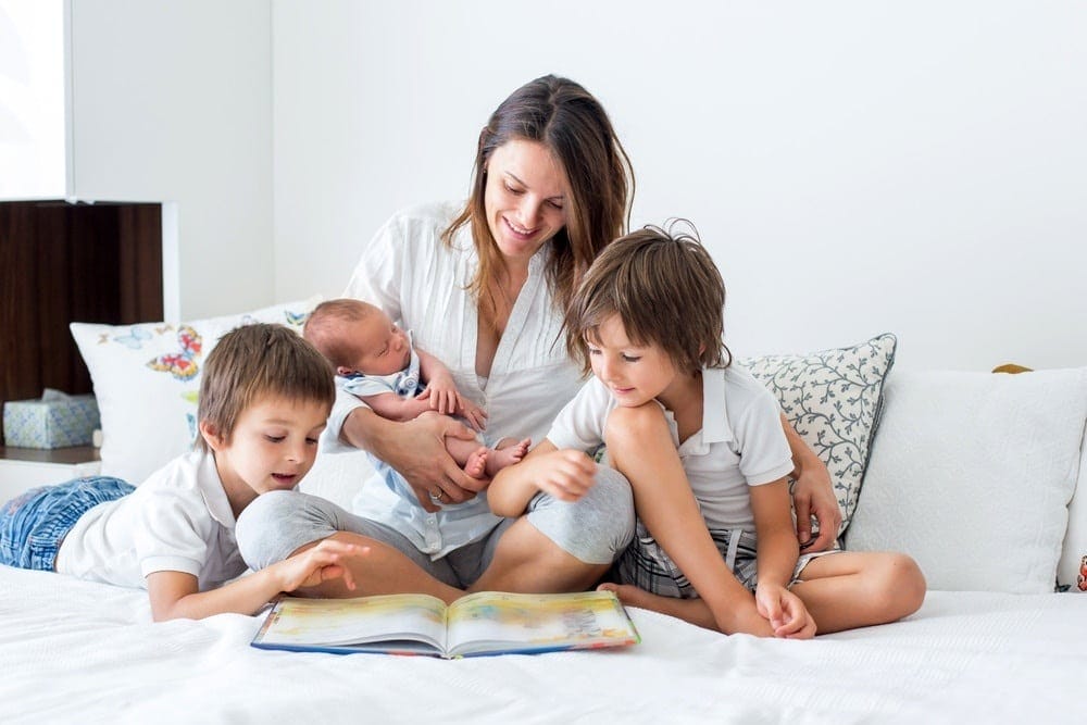 To the mama who’s done having babies mom holding a newborn beside two siblings