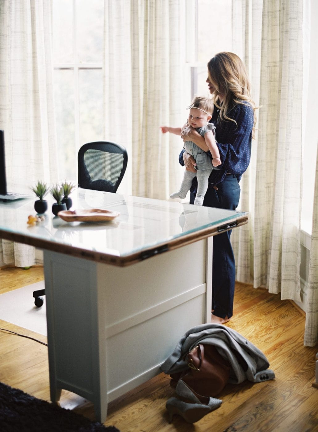 This mom was the best candidate for the job, regardless of her career gap woman standing and holding toddler by desk