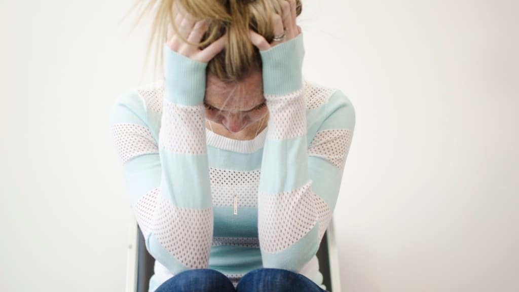 We need to talk about postpartum rage—and why it happens postpartum rage: woman with head between her hands