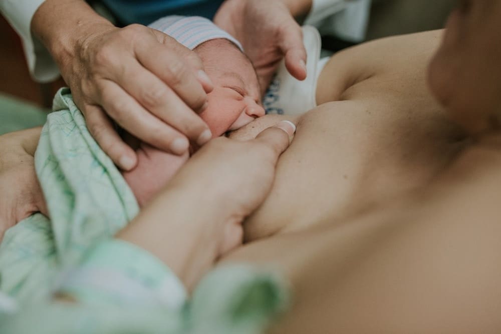 New mama: It’s okay to say breastfeeding is hard mom breastfeeding newborn in the hospital after birth