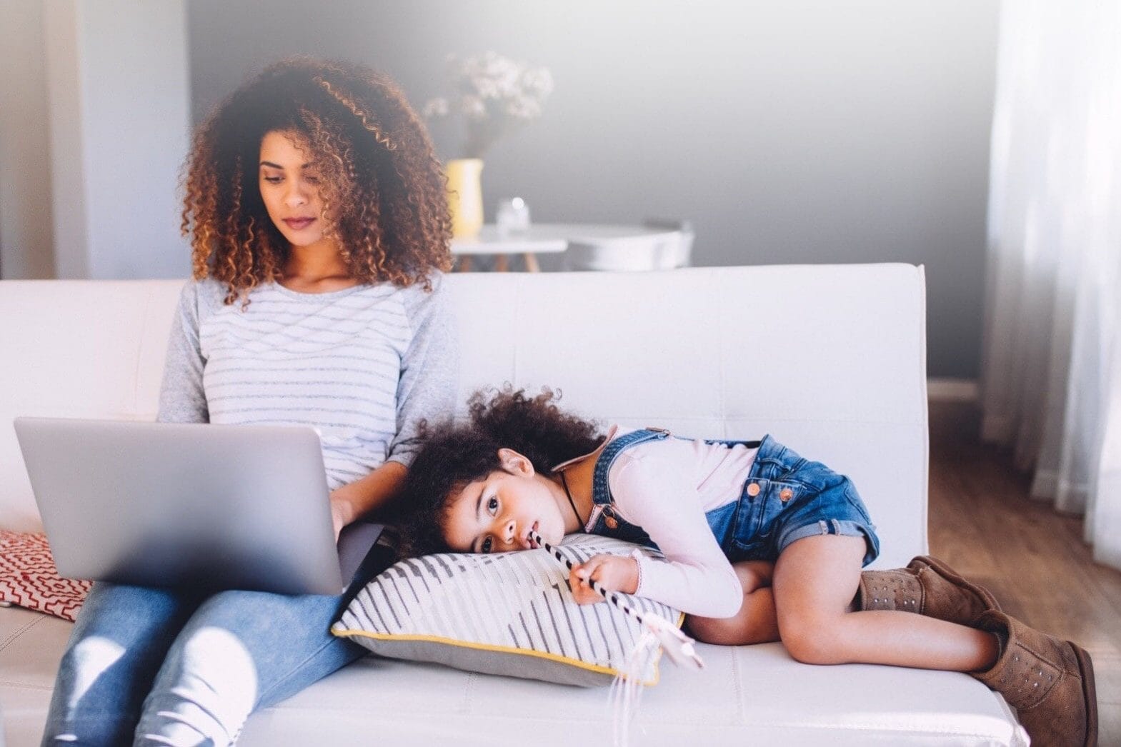 I had a wakeup call when my kids said ‘work’ was my favorite thing to do Child laying down next woman on laptop