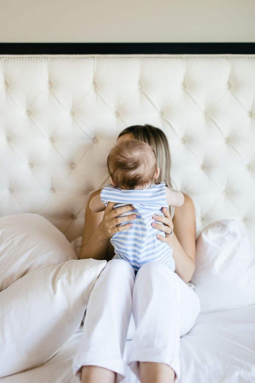 To the mama battling postpartum depression: You are stronger than you realize mom holding baby in bed