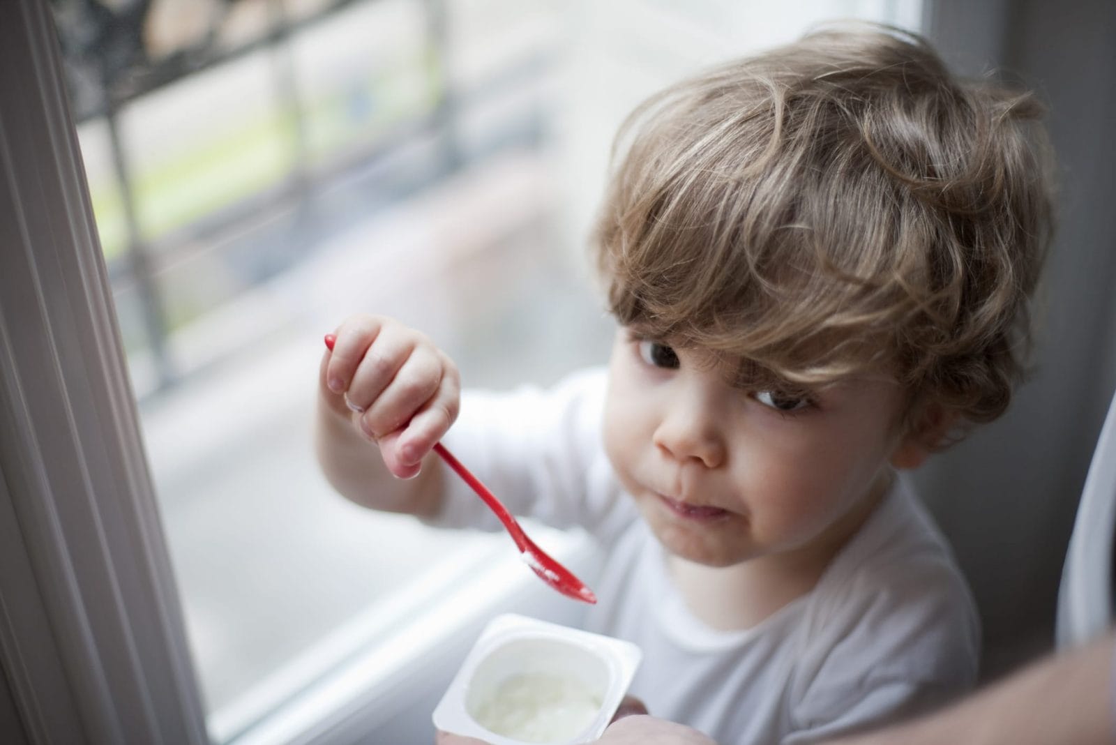 Why is my toddler suddenly a picky eater? little boy eating yogurt