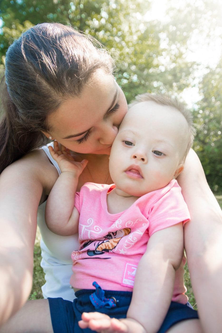 How I felt when the doctor told us our baby has Down Syndrome mom kissing her baby with Down Syndrome