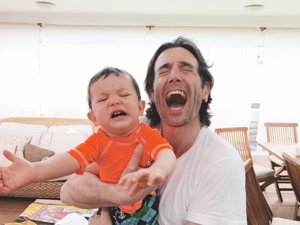 Why our partners stress us out more than our kids (and what we can do about it) dad smiling while toddler boy is crying