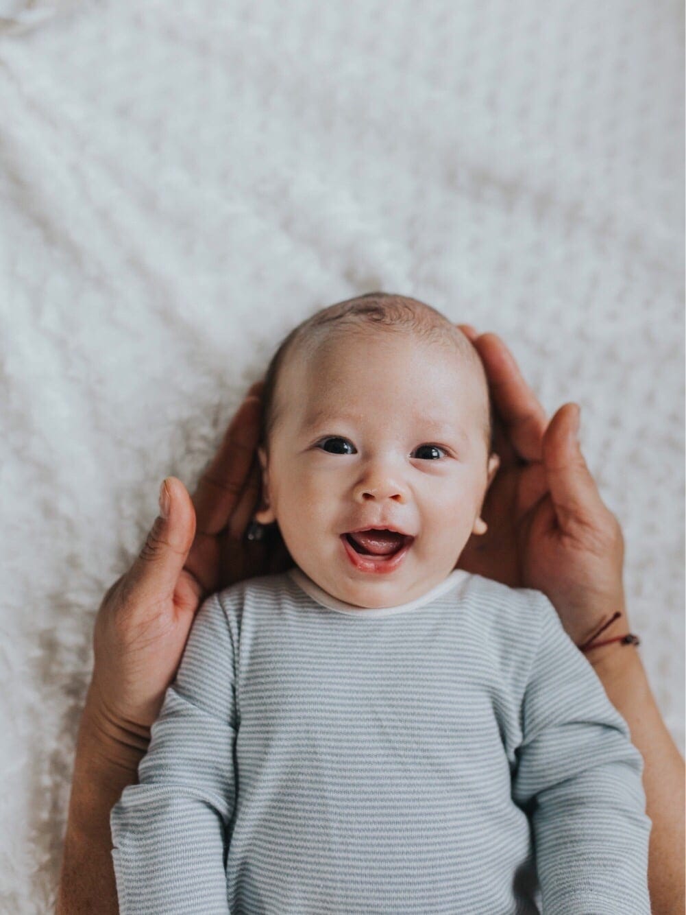 Best baby names for Leo babies mom holding baby's head in her hands- leo names