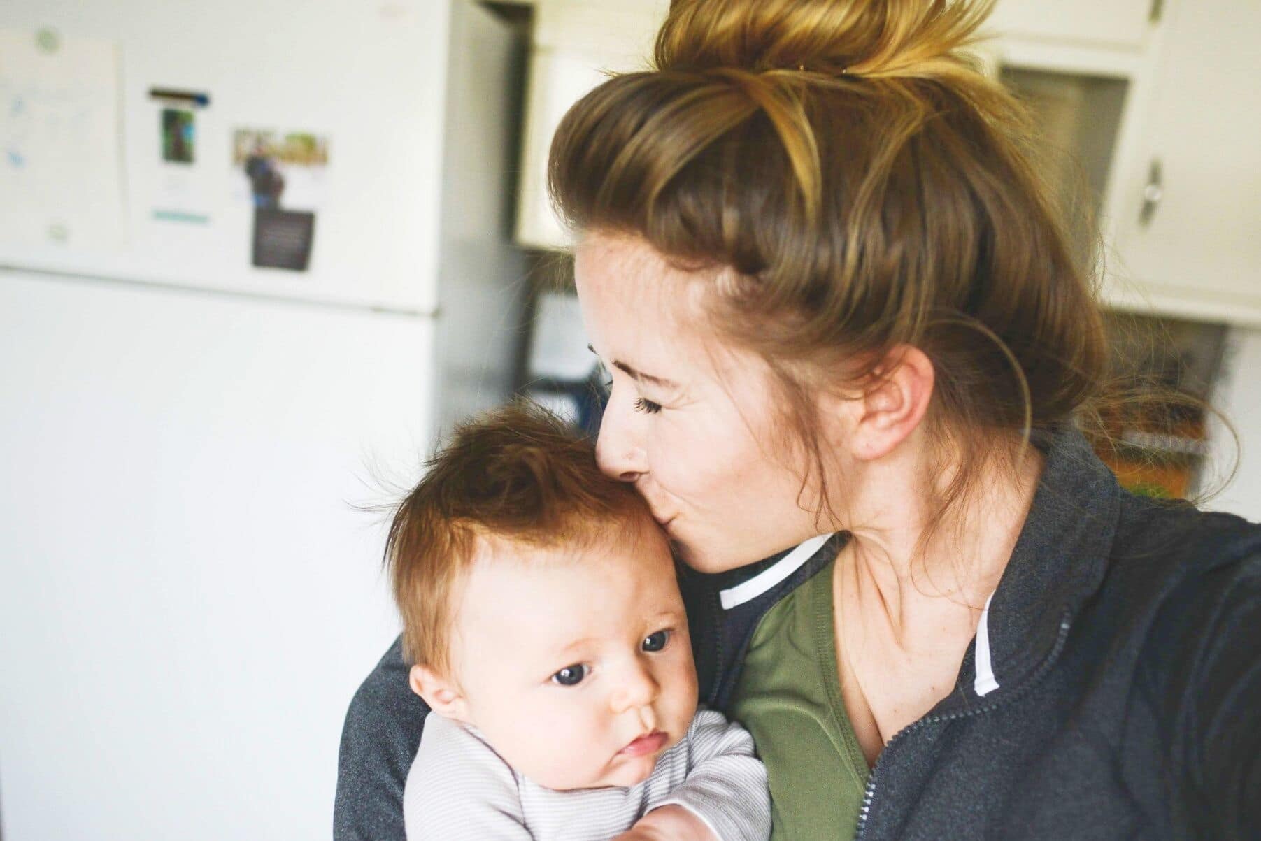 To the stranger who told me ‘it goes by so fast,’ I hear what you’re really saying mom kissing her child on the head- my baby is growing up so fast