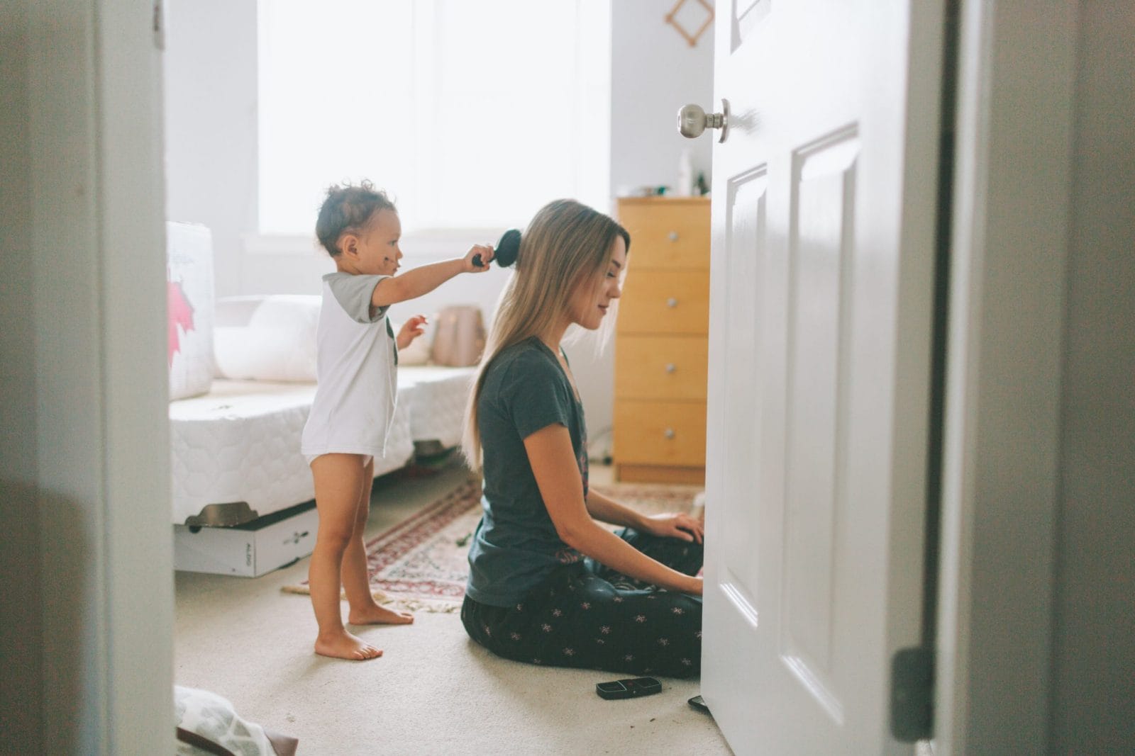 I can’t do it all as a SAHM—and that’s OK little boy brushing moms hair