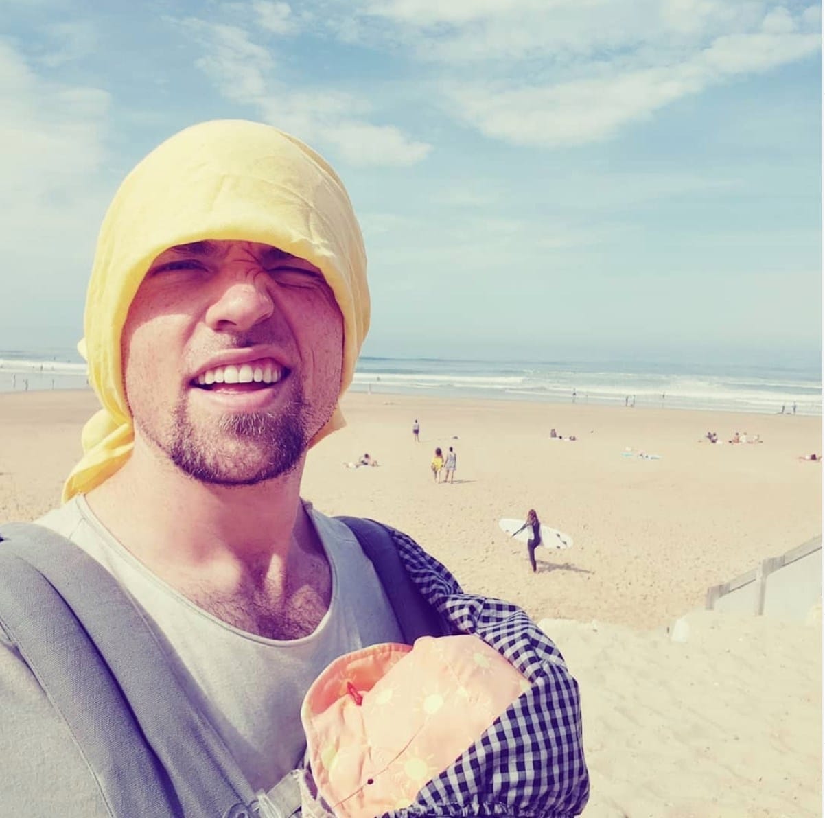 This dad’s post on supporting moms has gone viral and we couldn’t agree with him more dad holding baby on the beach