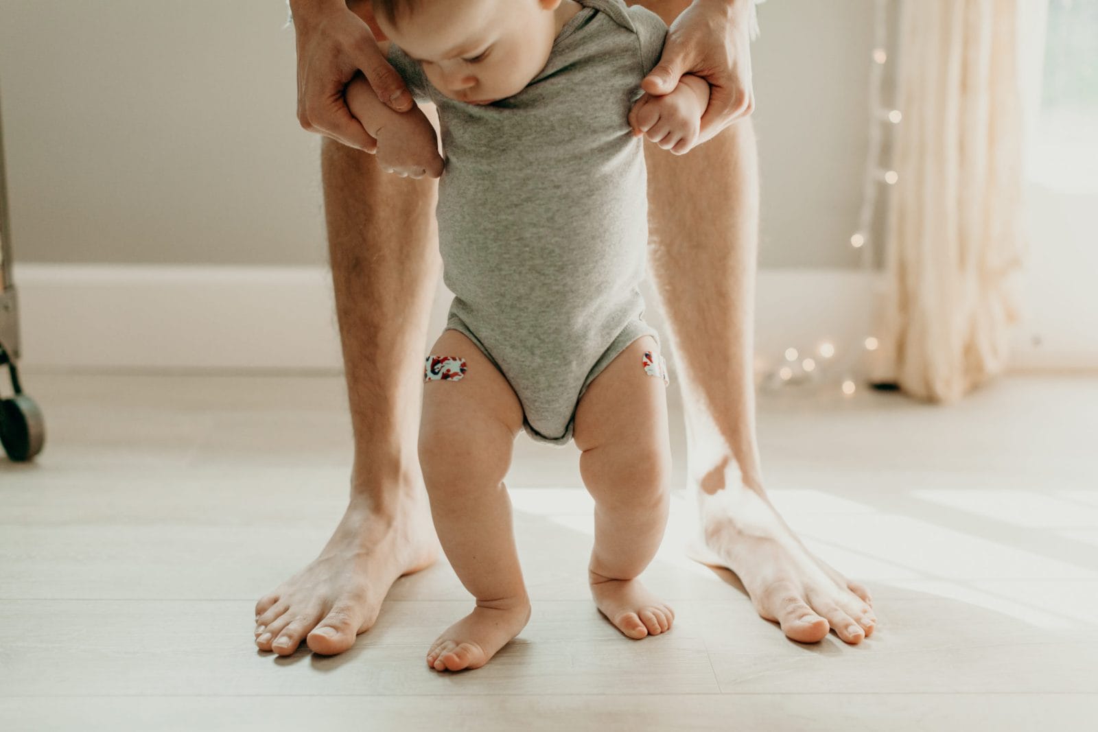 Why your parenting can’t be measured by when your baby hits their milestones mom helping baby walk