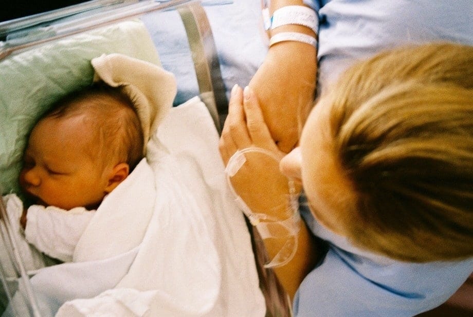 Is cord blood banking worth it? 7 factors to consider mother looks at sleeping baby in hospital bassinet - is cord blood banking worth it?