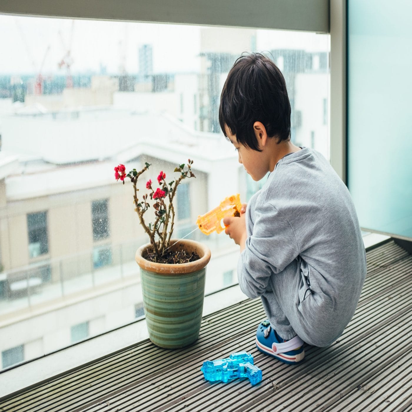 How to kid-proof houseplants, according to a plant expert kid watering houseplant