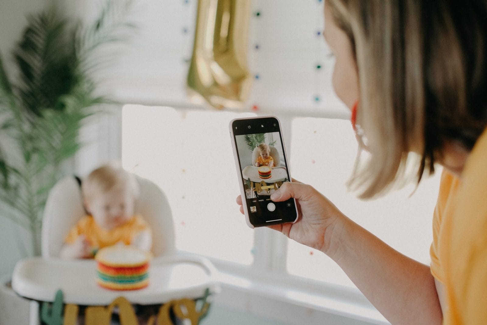I don’t post photos of my child on social media mom taking a picture of baby sitting in a high chair