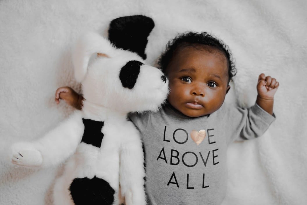 It’s flu season—and it’s okay to tell people not to kiss your baby baby laying next to a stuffed animal
