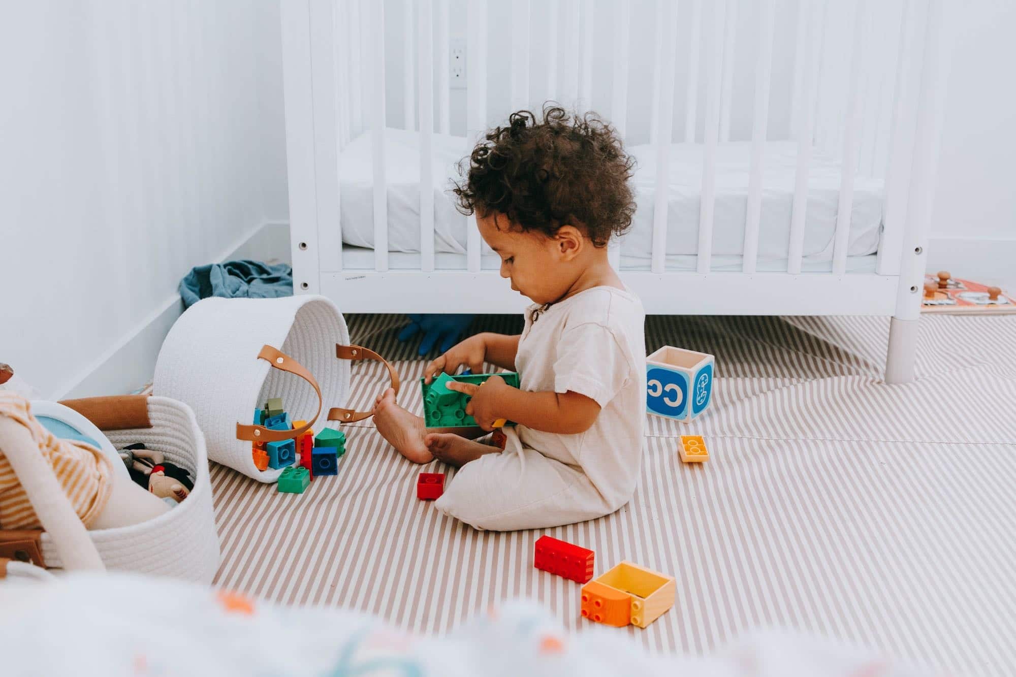 Montessori at home: 10 activities under $10 little boy playing with toys on his floor