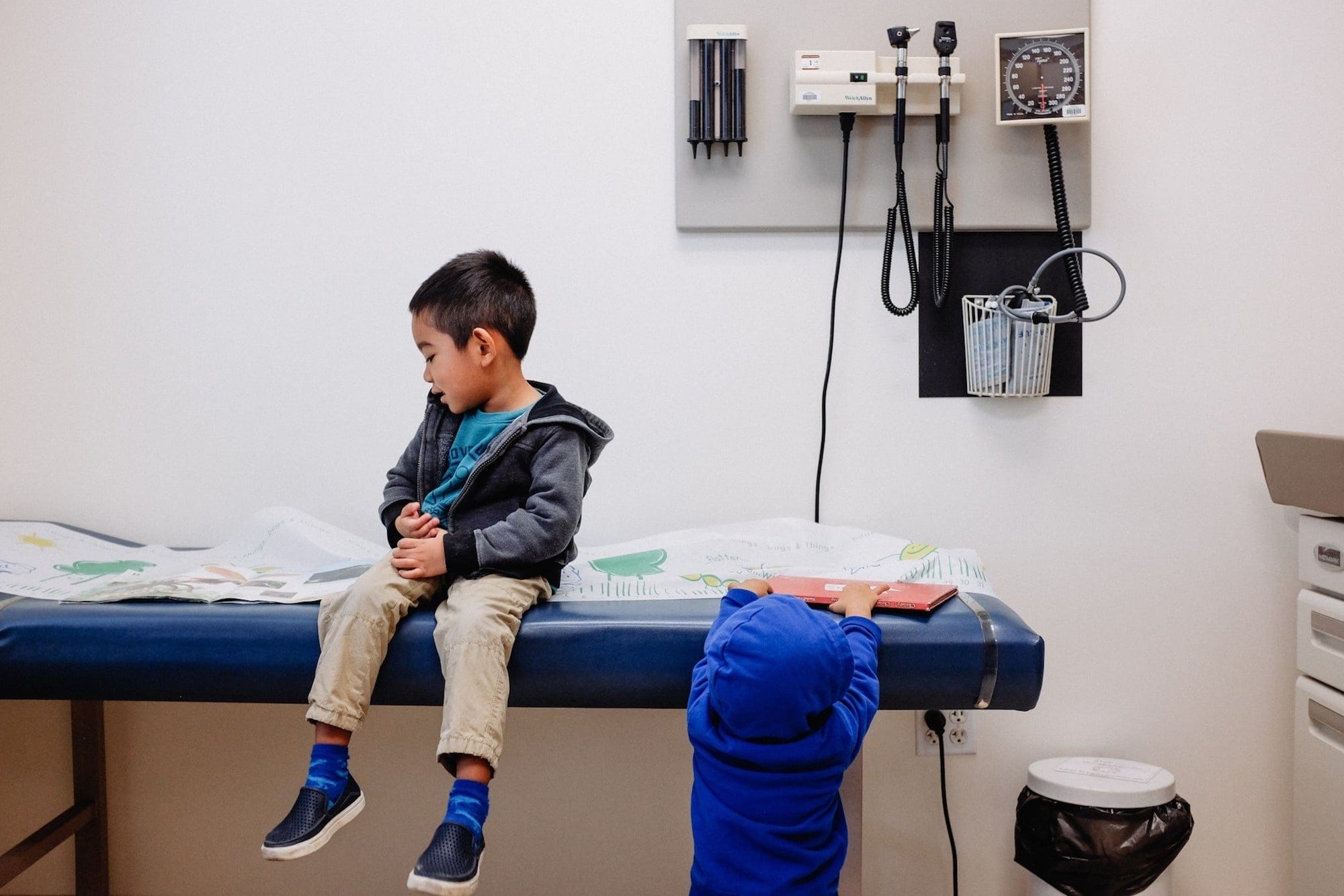 Is it too late for kids to get the flu shot? little boy sitting at the doctors office