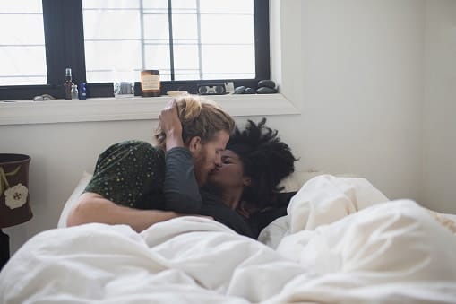 Why your partner asks for postpartum sex, according to a psychologist couple cuddling in bed