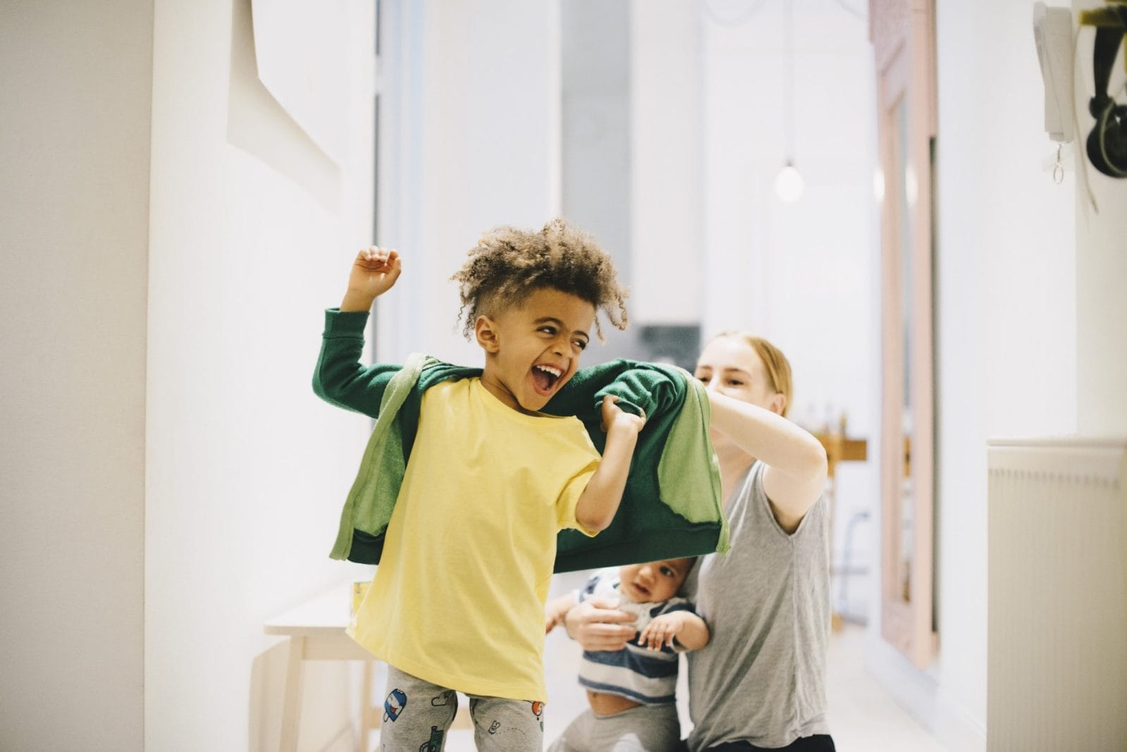 It’s science: Why your child fights getting dressed (and how to prevent the battle) dad helping son put on a jacket