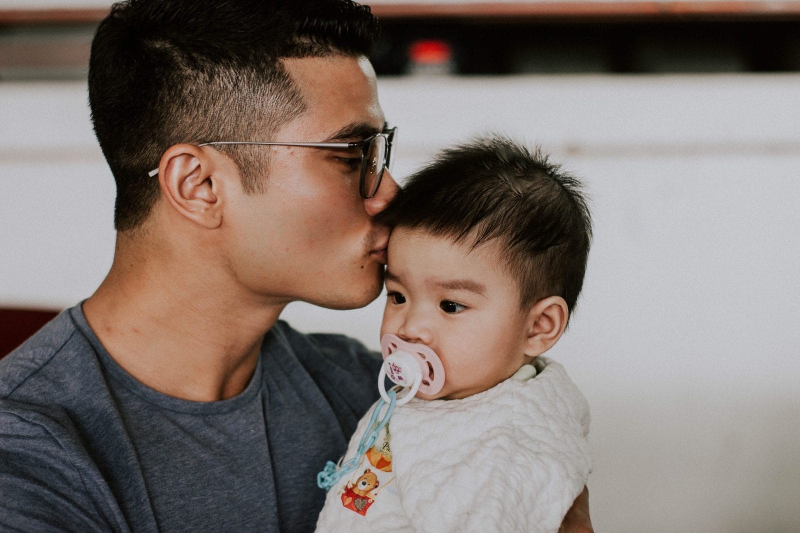 Why #yearofthemother is good for dads, too father kissing head of his infant