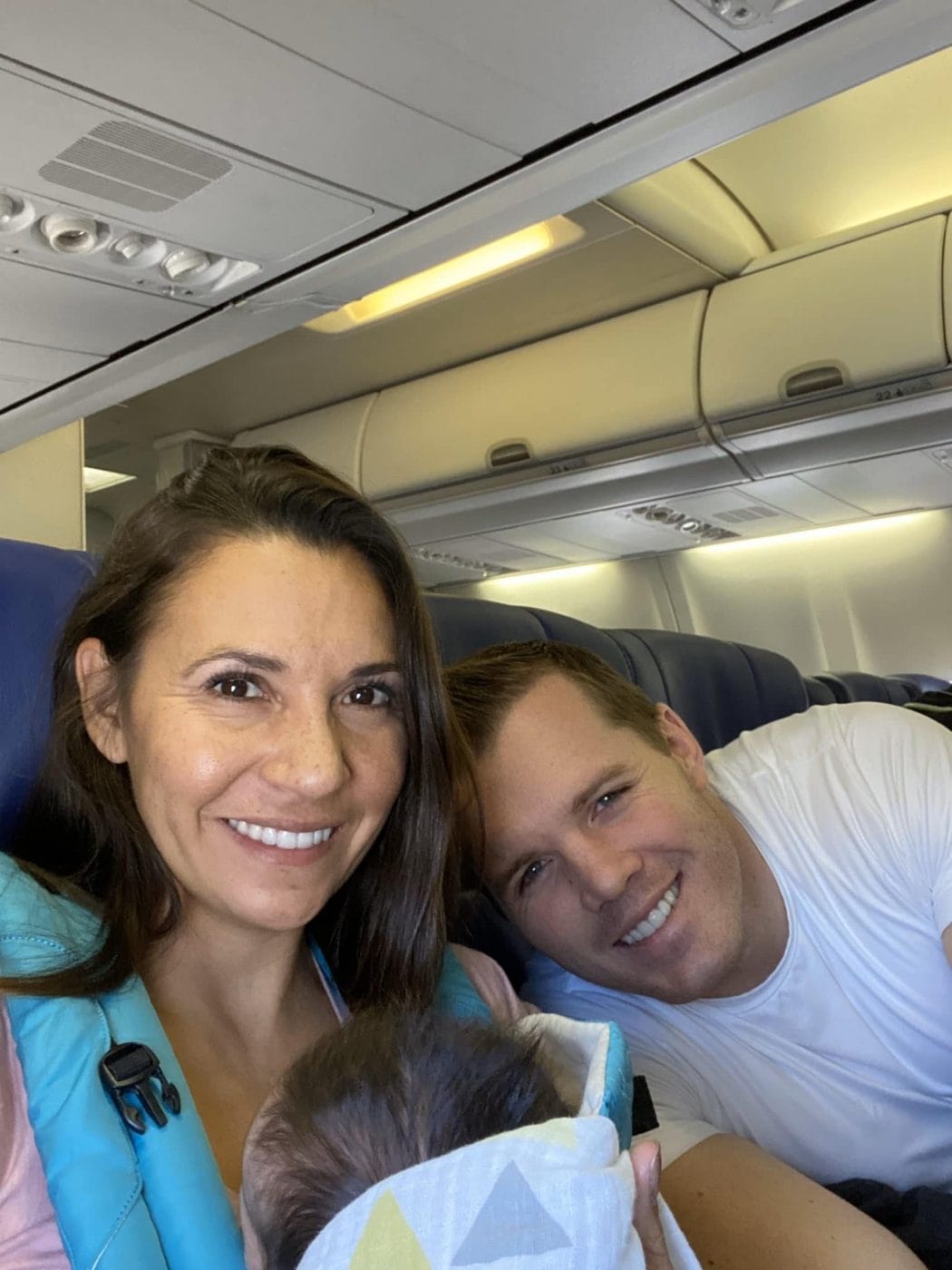These parents flying home with their adopted baby got a surprise in-flight baby shower couple on a plane with a newborn baby