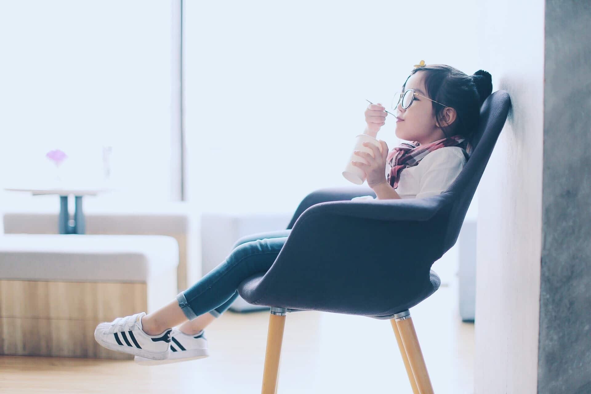 7 hacks for simplifying after-school snacks little girl sitting in a chair eating