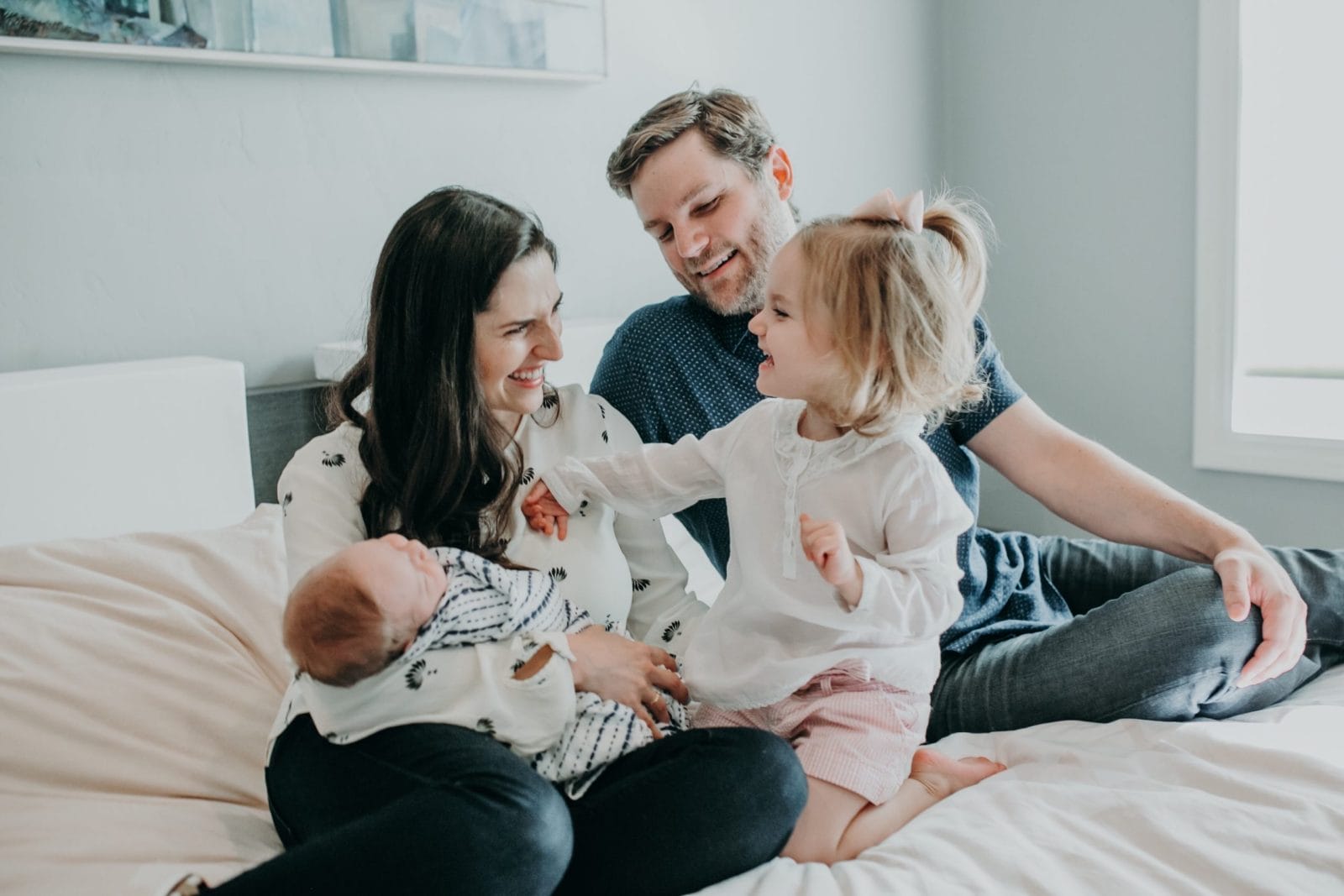 78% of Millennial parents think they’re doing a better job than their parents, says new survey mom and dad holding a baby and a toddler