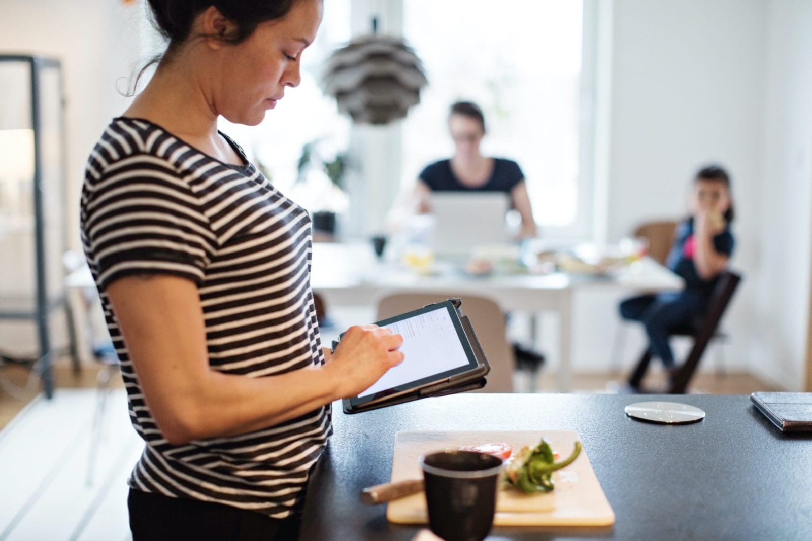 Coronavirus: How to flatten your anxiety while flattening the curve woman on a tablet making dinner