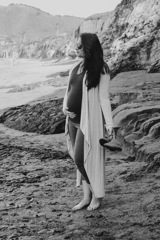 This viral post explains how pregnant women everywhere feel right now black and white photo of pregnant woman holding belly on a beach