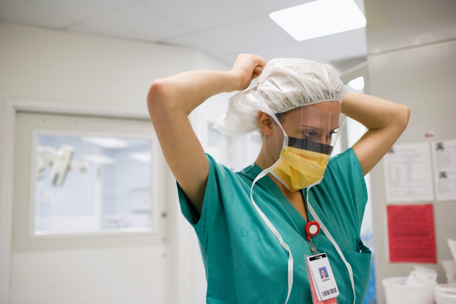 This viral post from an ER nurse about separating from her child is heartbreaking ER nurse tying her hair cap