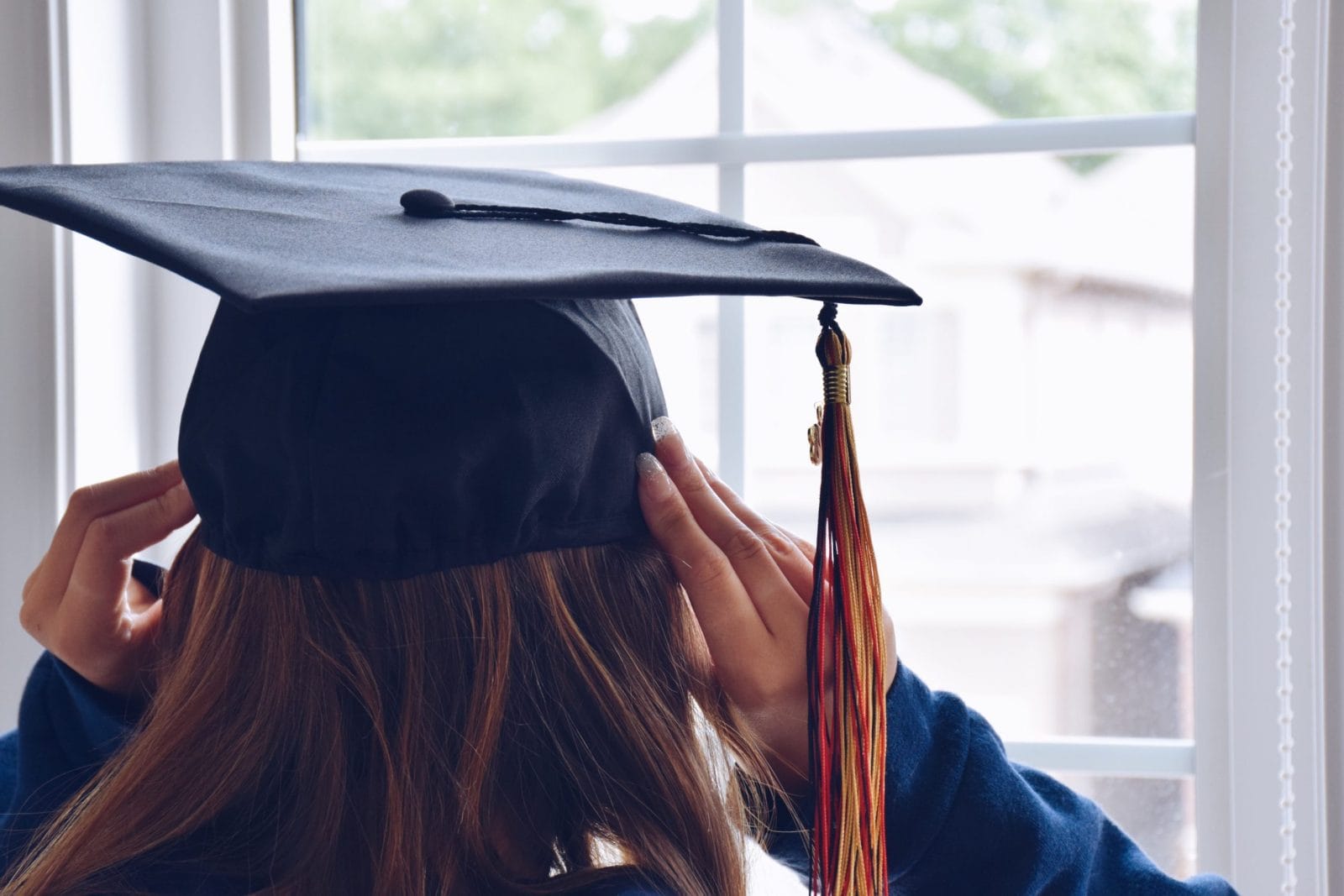 The year without graduation: To the class of 2020 girl putting on her graduation cap