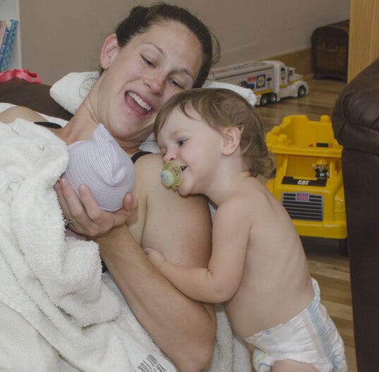 Should I switch to a home birth during the COVID-19 pandemic? mom showing toddler his new sibling