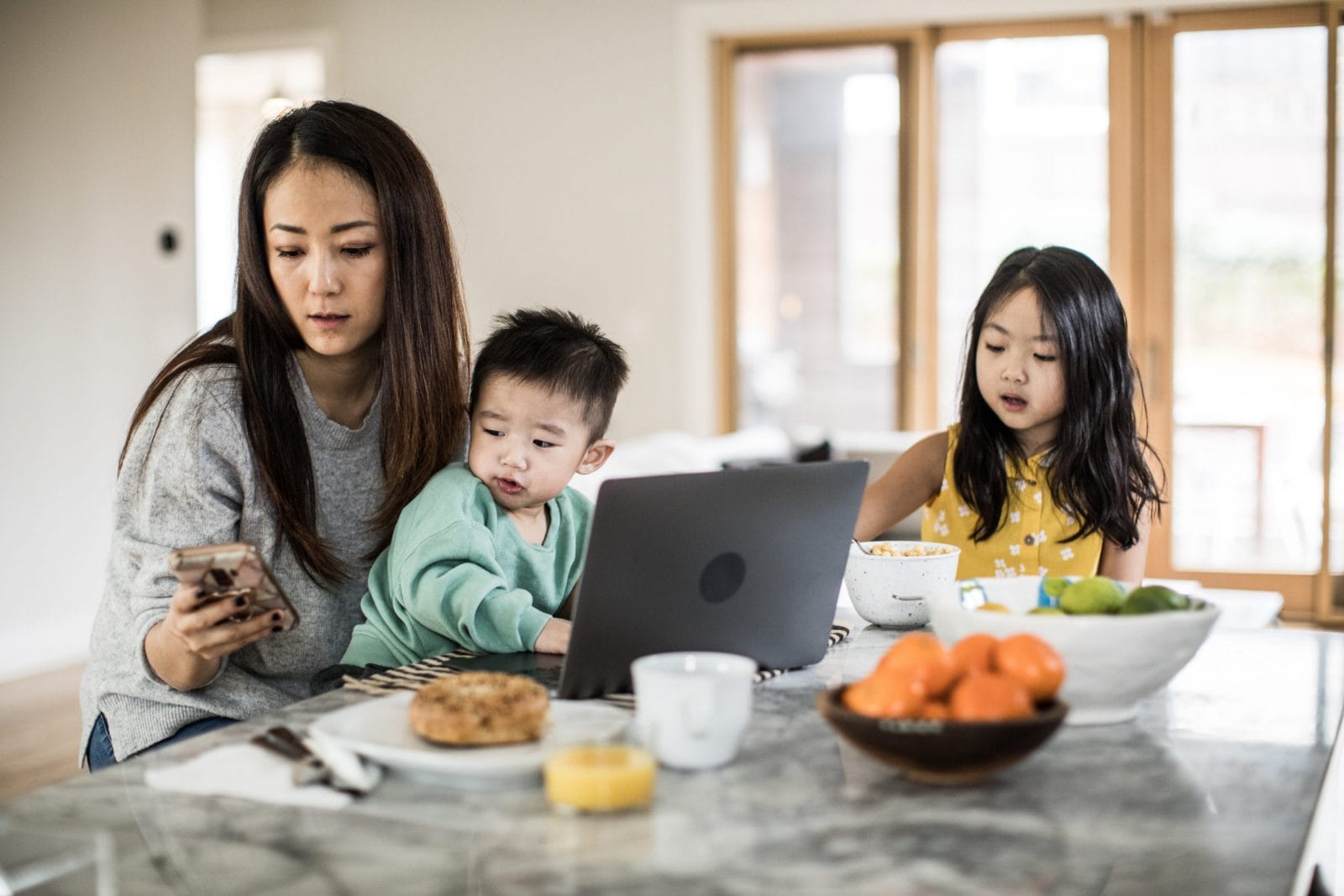 Why employees deserve an extra day off this month mom working while two kids eat breakfast