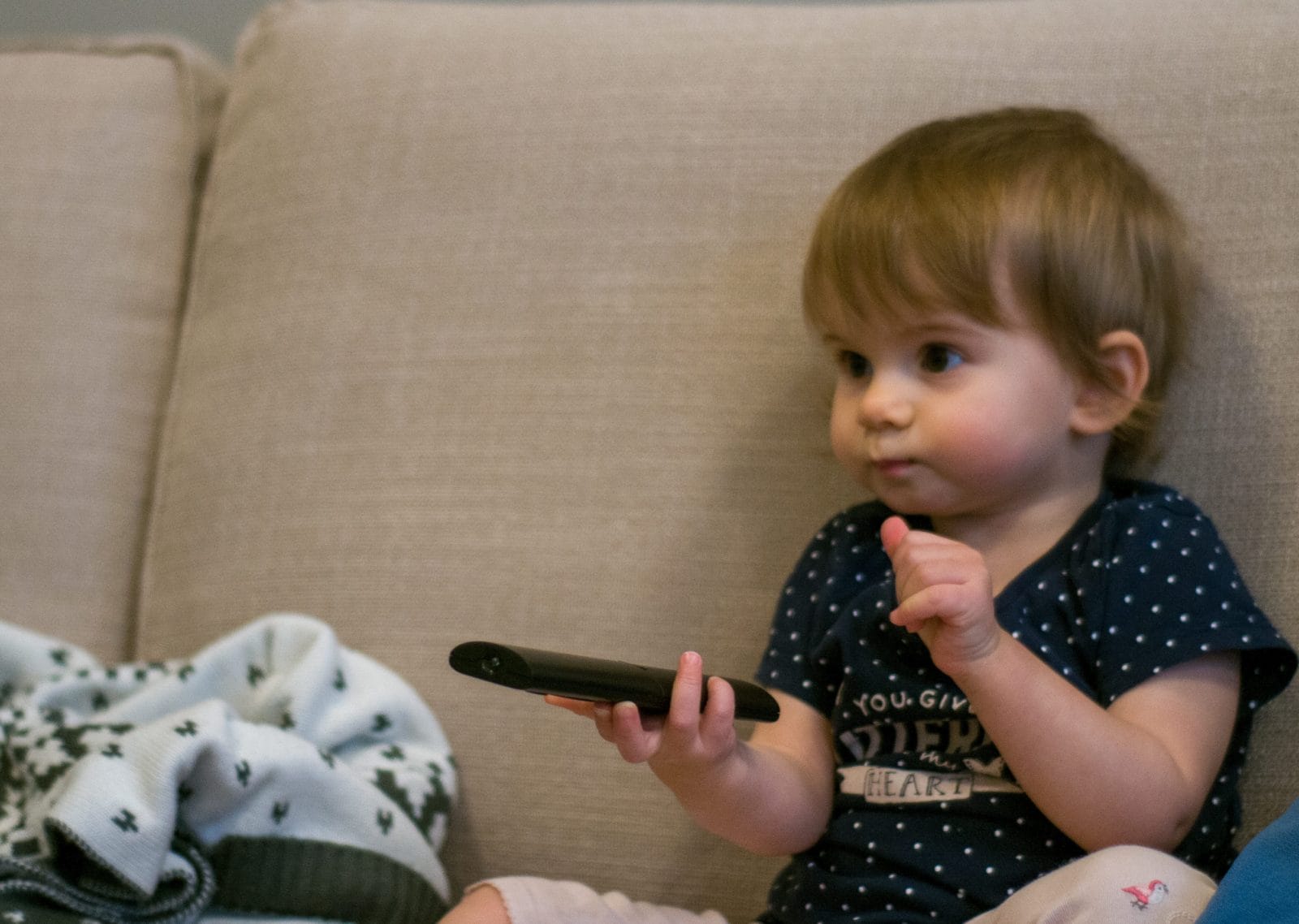 8 things babies find irresistible—and what to let them play with instead baby playing with a remote control, one of the most dangerous household items for babies