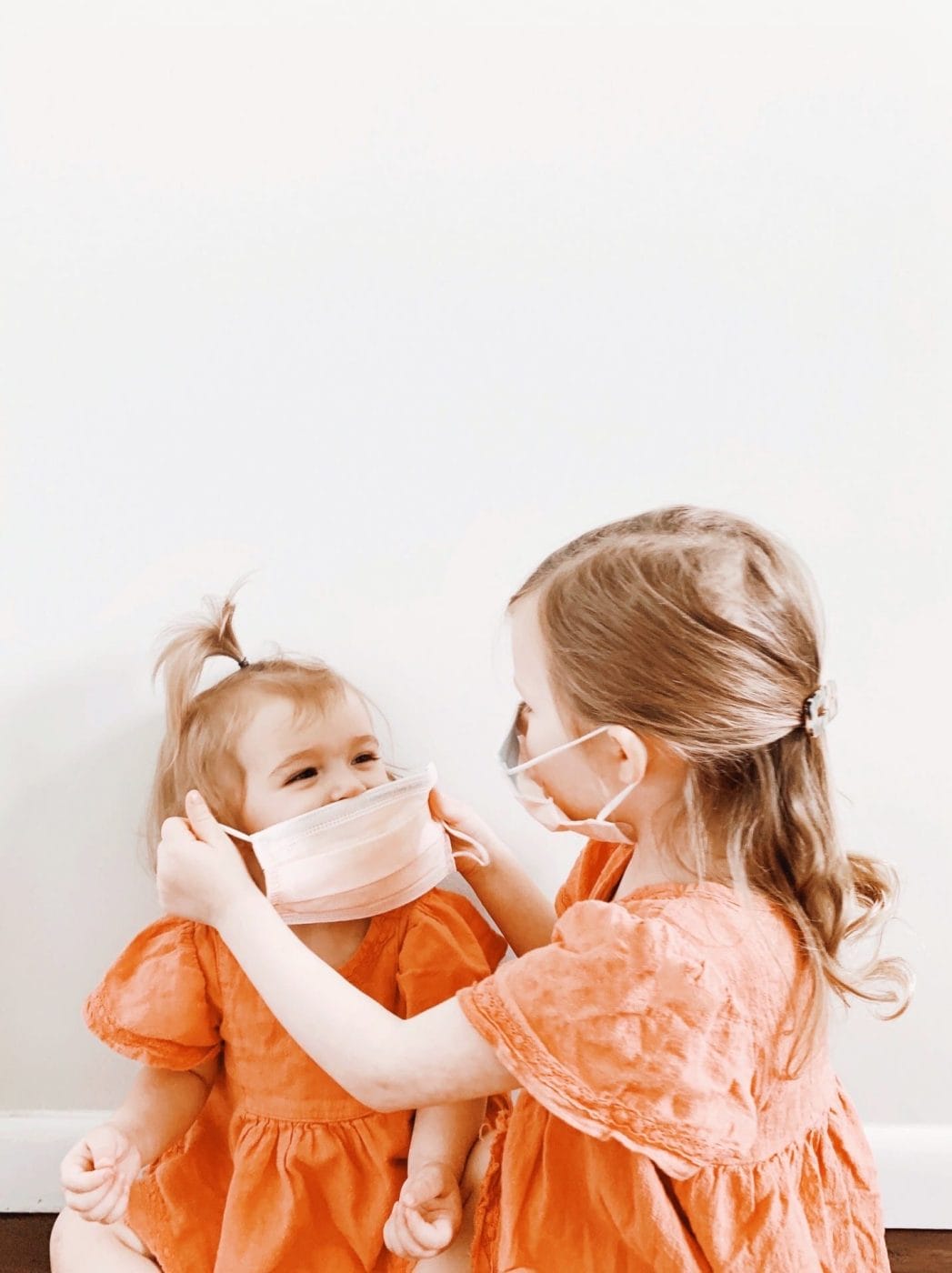 This (free!) book helps kids with autism understand mask-wearing child helping another child put on a mask
