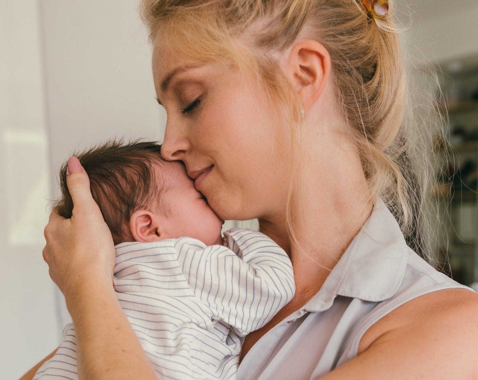 I wasn’t prepared for the grief each milestone would bring mom snuggling newborn baby against her cheek