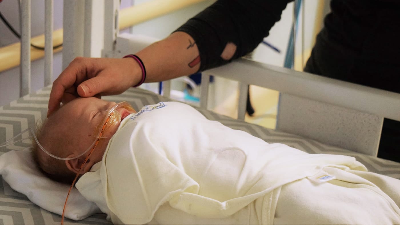 How to navigate the stress of the NICU during a pandemic—according to a neonatologist mom comforting newborn in the NICU
