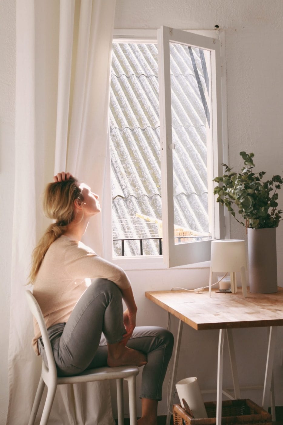 Trying to conceive after miscarriage isn’t easy—but here’s how to prepare yourself to try again woman sitting at desk staring out the window - thinking about trying to conceive after miscarriage