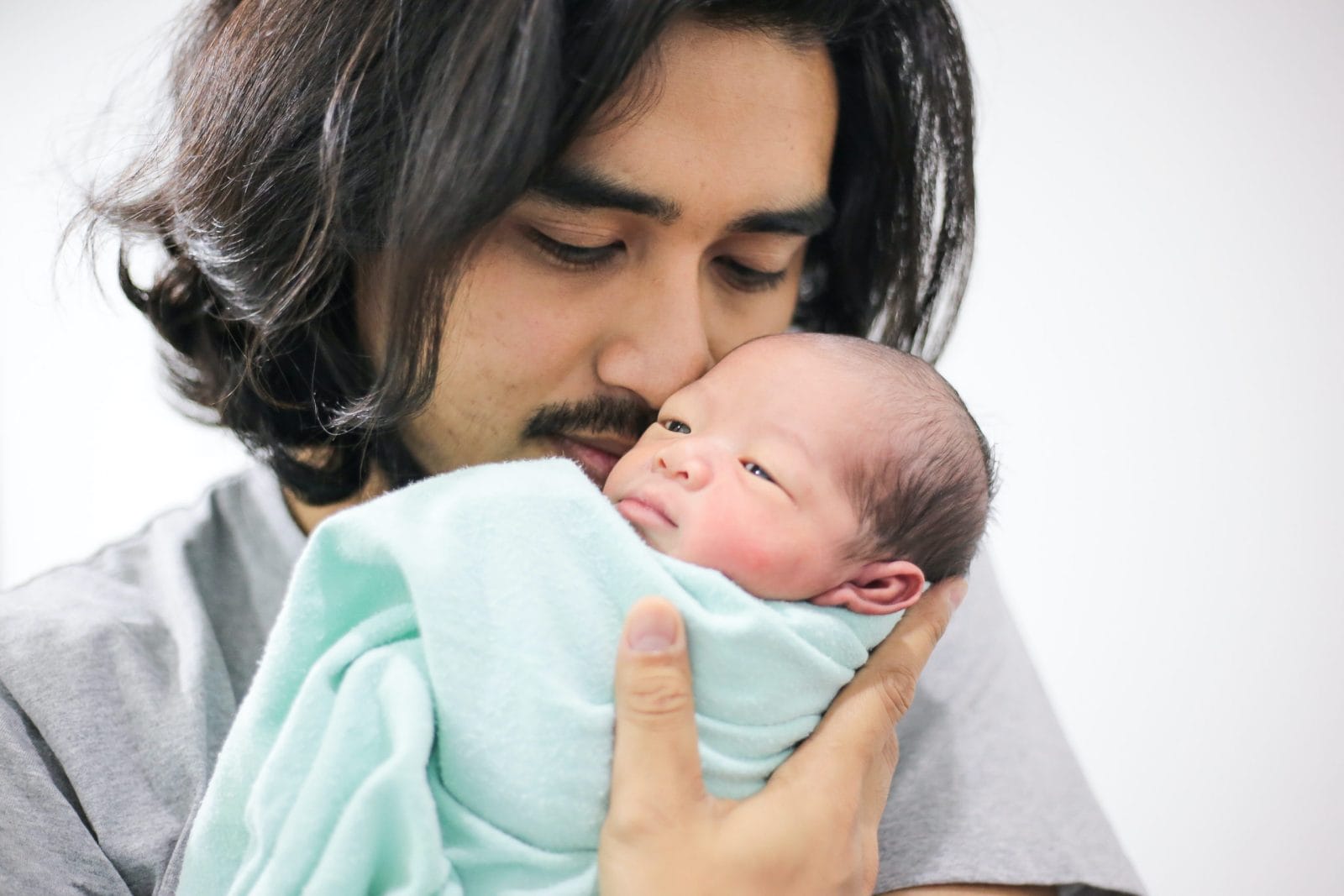 France wants to double their paid paternity leave—and make it mandatory dad kissing newborn baby