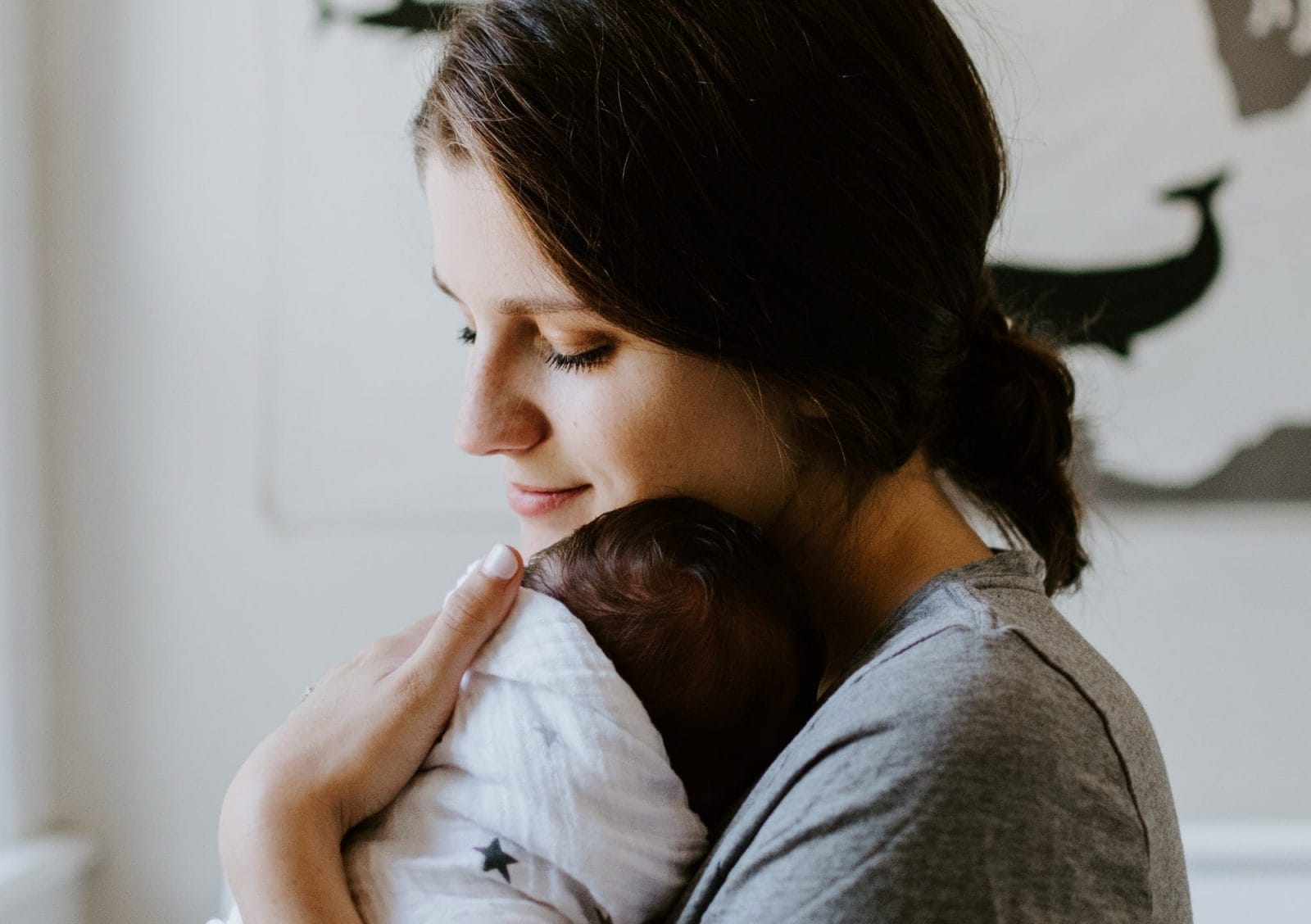 Having a newborn during a pandemic is the hardest thing I’ve ever done mom snuggling a newborn
