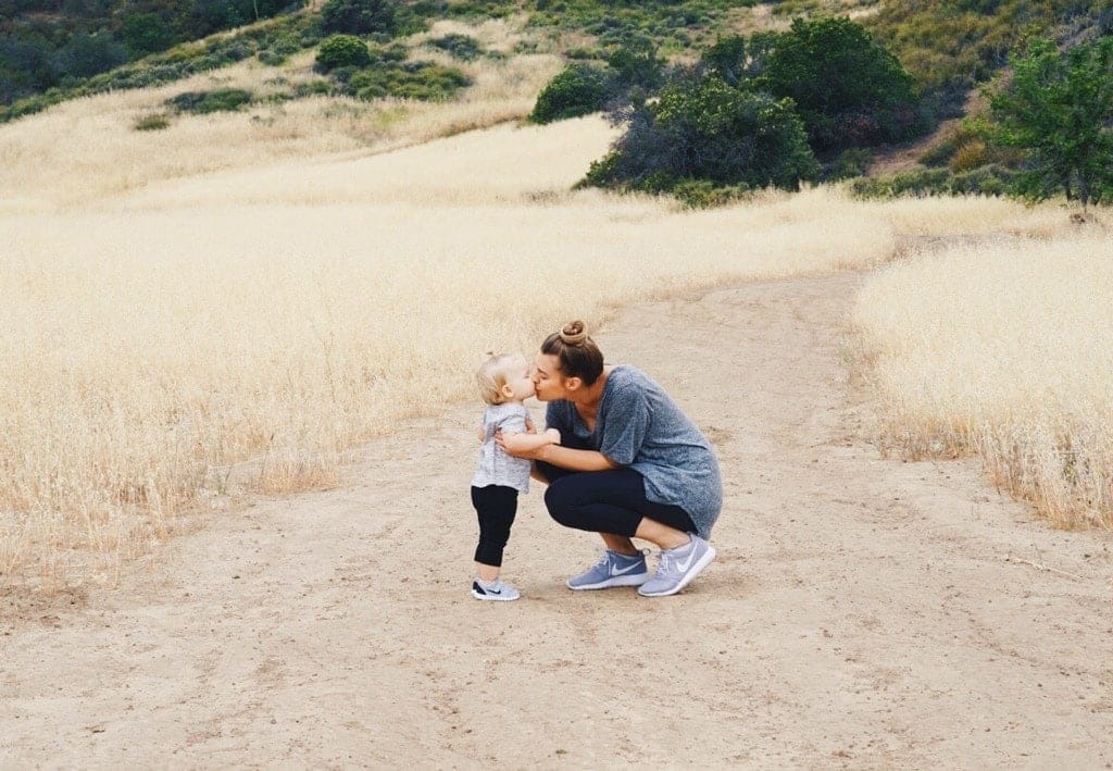 How parental affection shapes a child’s lifelong happiness mom kissing child outside