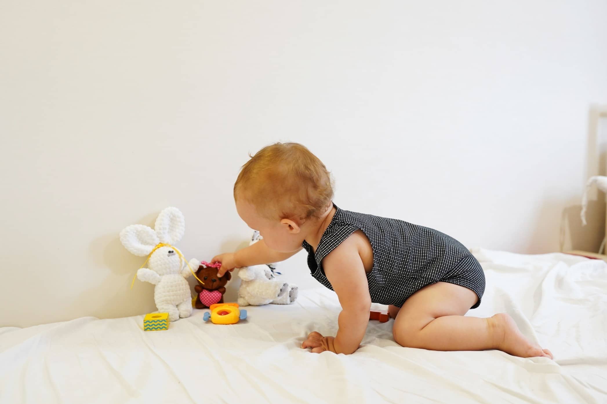 6 Montessori activities for babies—no new toys required baby selecting a toy independently, one of the best montessori baby activities