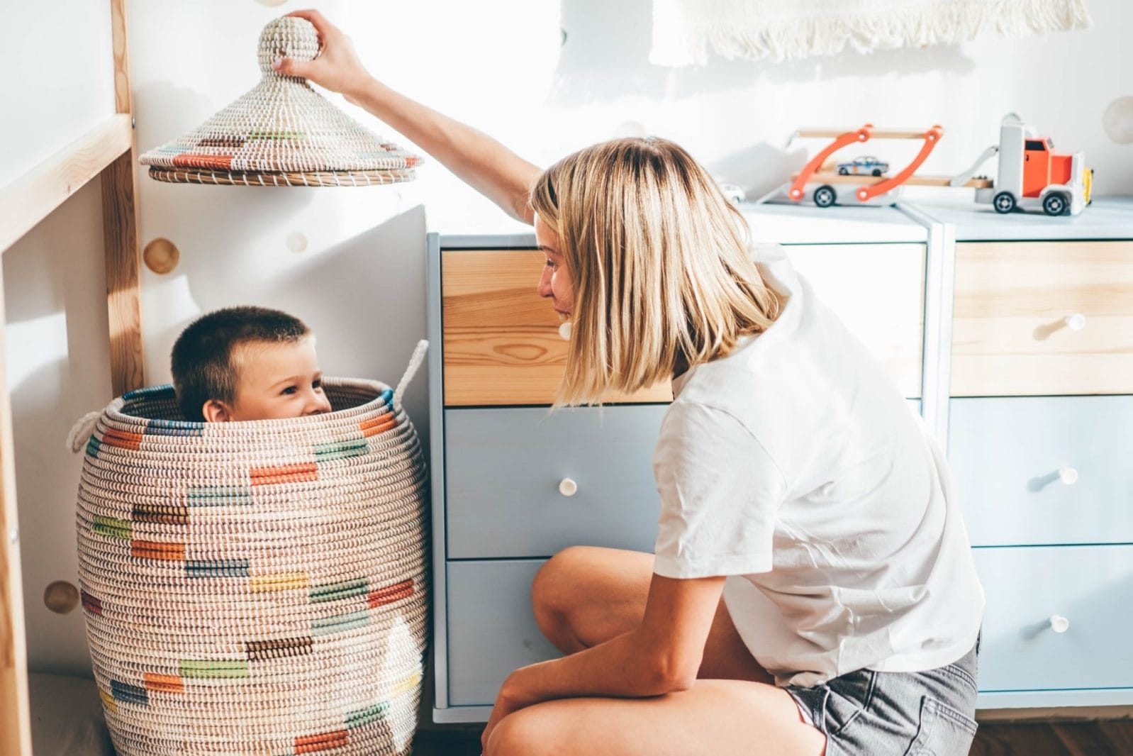 How to get your kids to listen—without yelling mom playing with son in a hamper